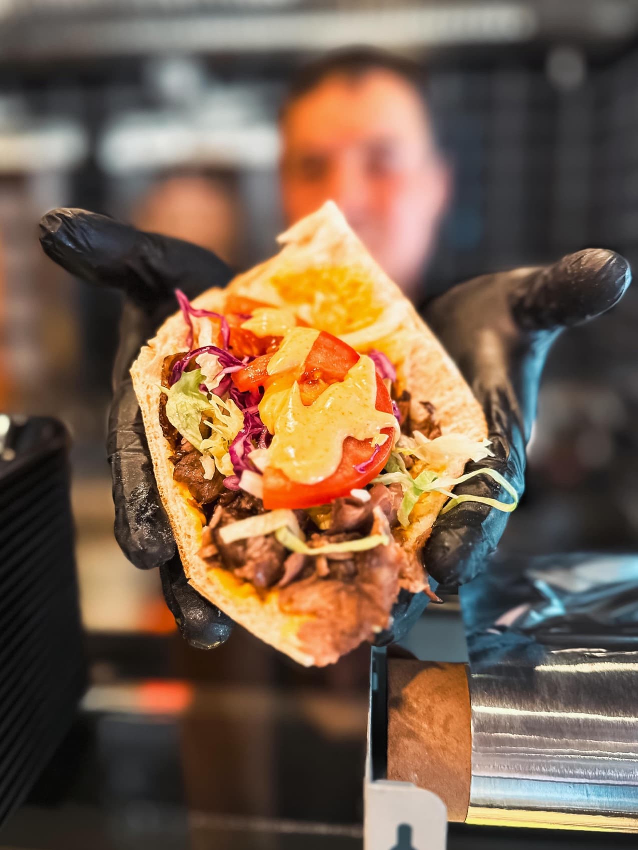Frisch belegter Kebab wird über den Tresen gereicht