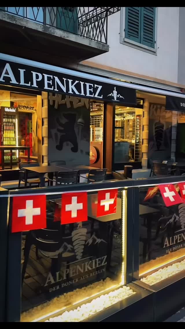 Alpenkiez am Abend, Schweizer Fahnen vor der Terrasse